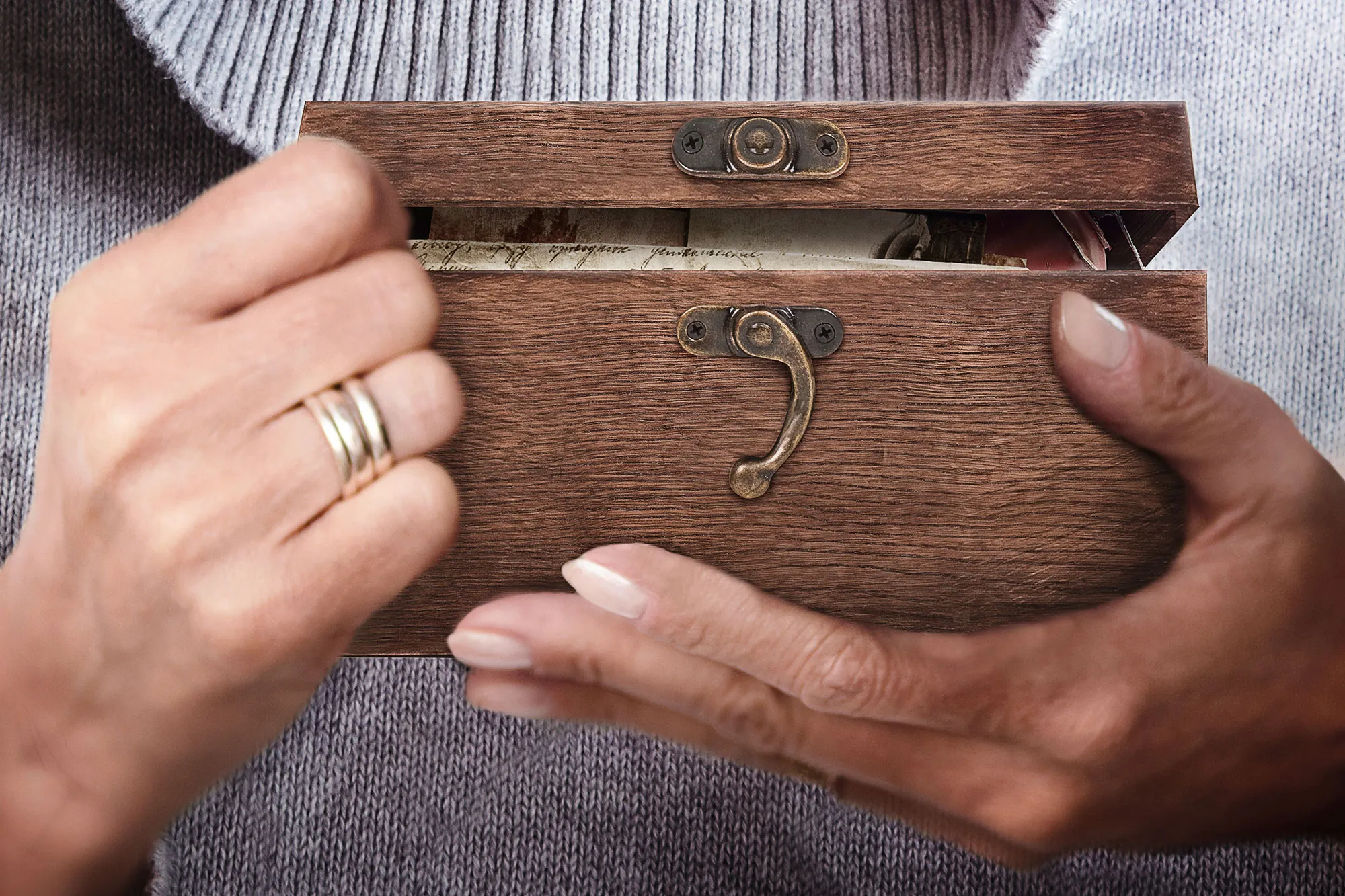 Großaufnahme eines Holzkästchens in den Händen einer älteren Person