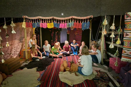 Eine Gruppe von Kindern sitzt in einem Nomadenzelt