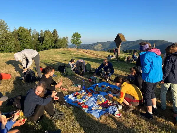 Wandergruppe beim Frühstück im Freien