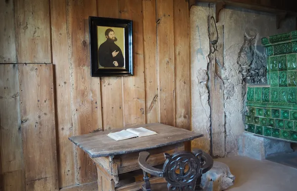 Blick in Lutherstube auf Holztisch und Porträt von Martin Luther