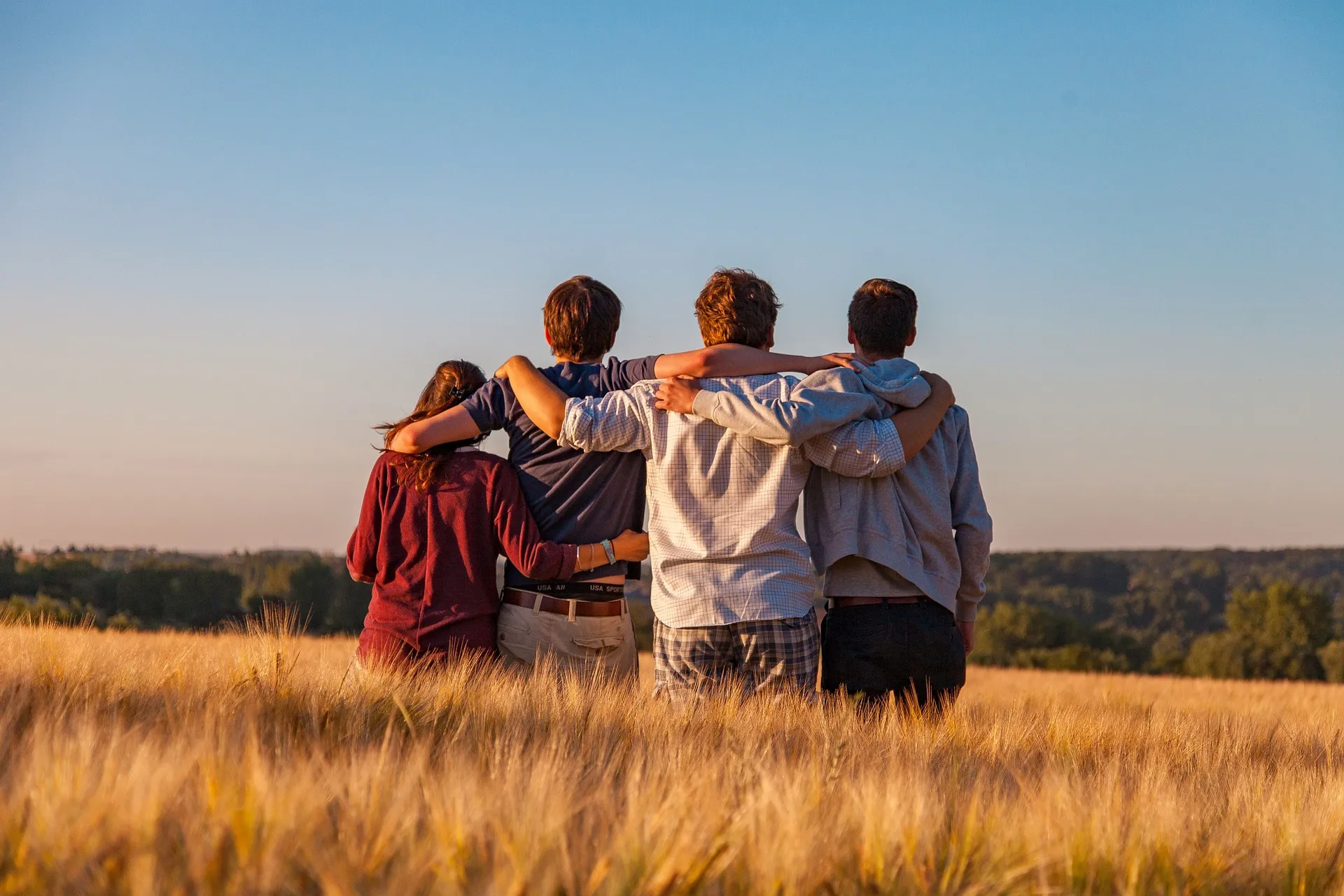 Quelle: Dim Hou/Pixabay vier junge Menschen von hinten, halten sich an den Schultern