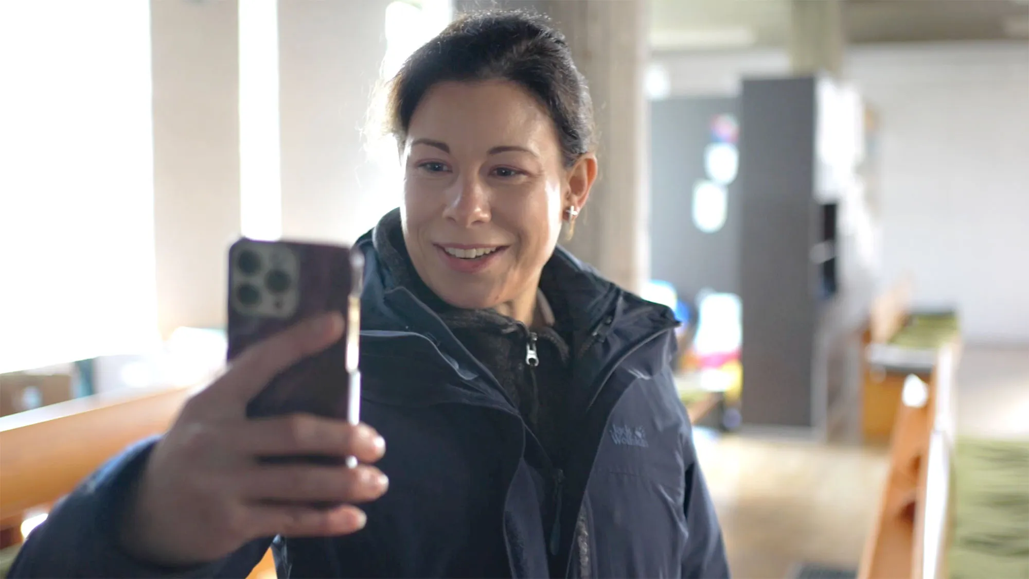 Inselpfarrerin Anna Bier schaut auf ihr Smartphone