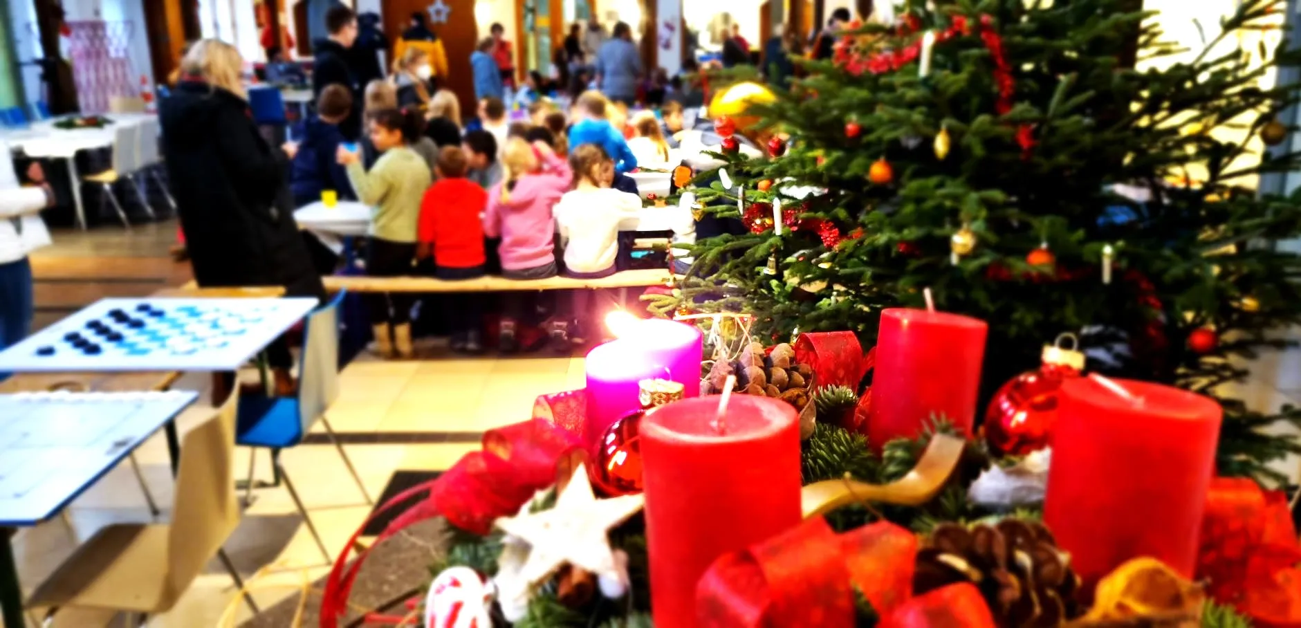 Kinder bei der Eröffnung der KinderVesperkirche mit Adventskranz