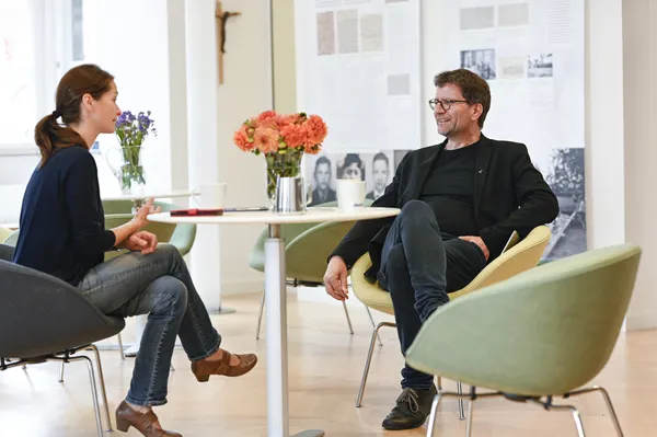 zwei Menschen sitzen sich im Gespräch gegenüber