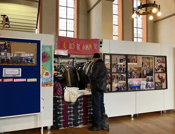 Mann vor Kleiderkammer in der Johanniskirche Karlsruhe