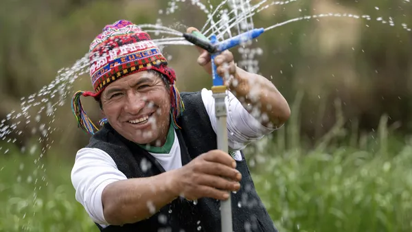 Ein Mann aus Peru freut sich über eine funktionierende Sprinkleranlage