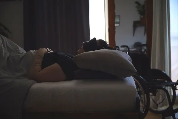 kranke liegt im abgedunkelten Zimmer