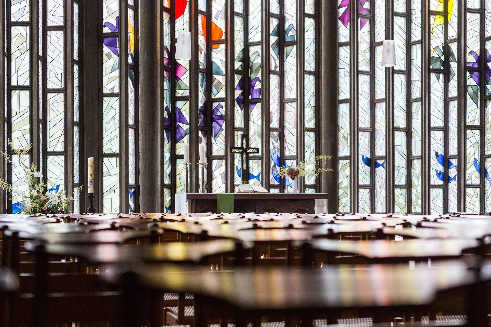 Blick über Kirchenstühle in den Altarraum der Ludwigskirche Freiburg