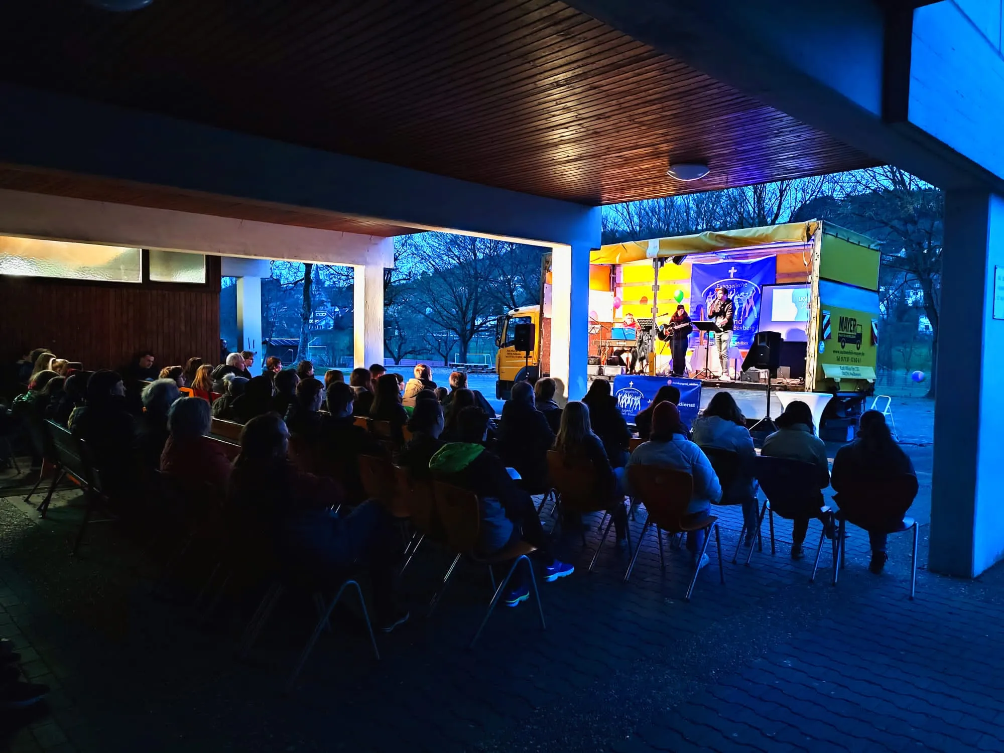 Bühne auf dem LKW beim Jugendgottesdienst und Besucher:innen