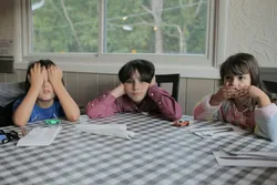 3 Kinder sitzen am Tisch