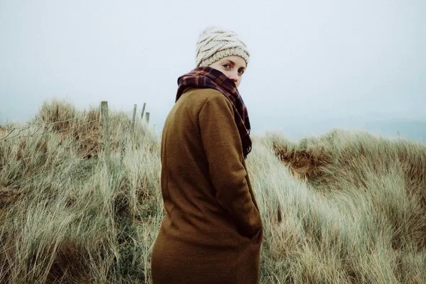 Frau im hohen Gras und blick in die Kamera