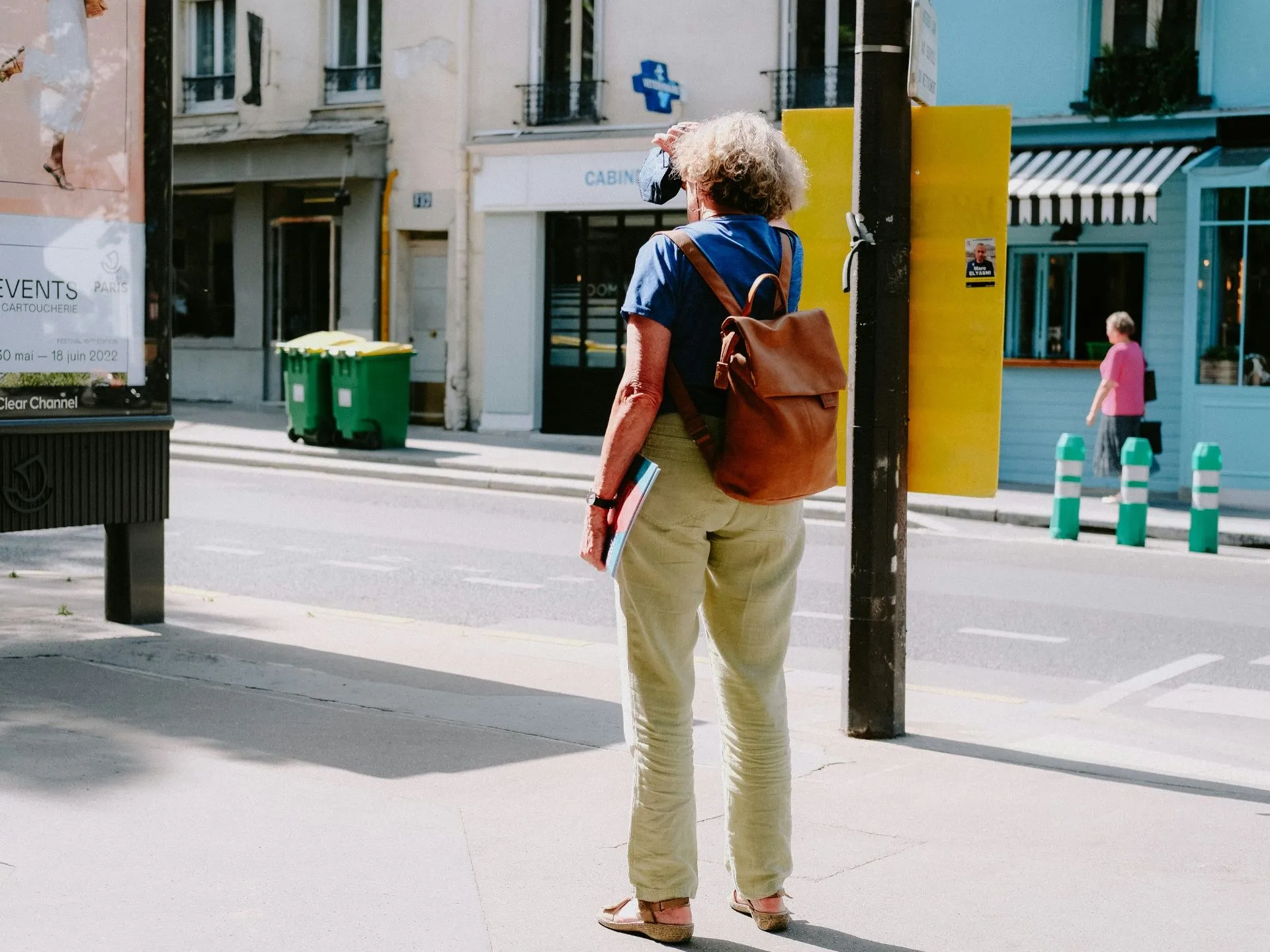 Frau mit Rucksack steht am Straßenrand