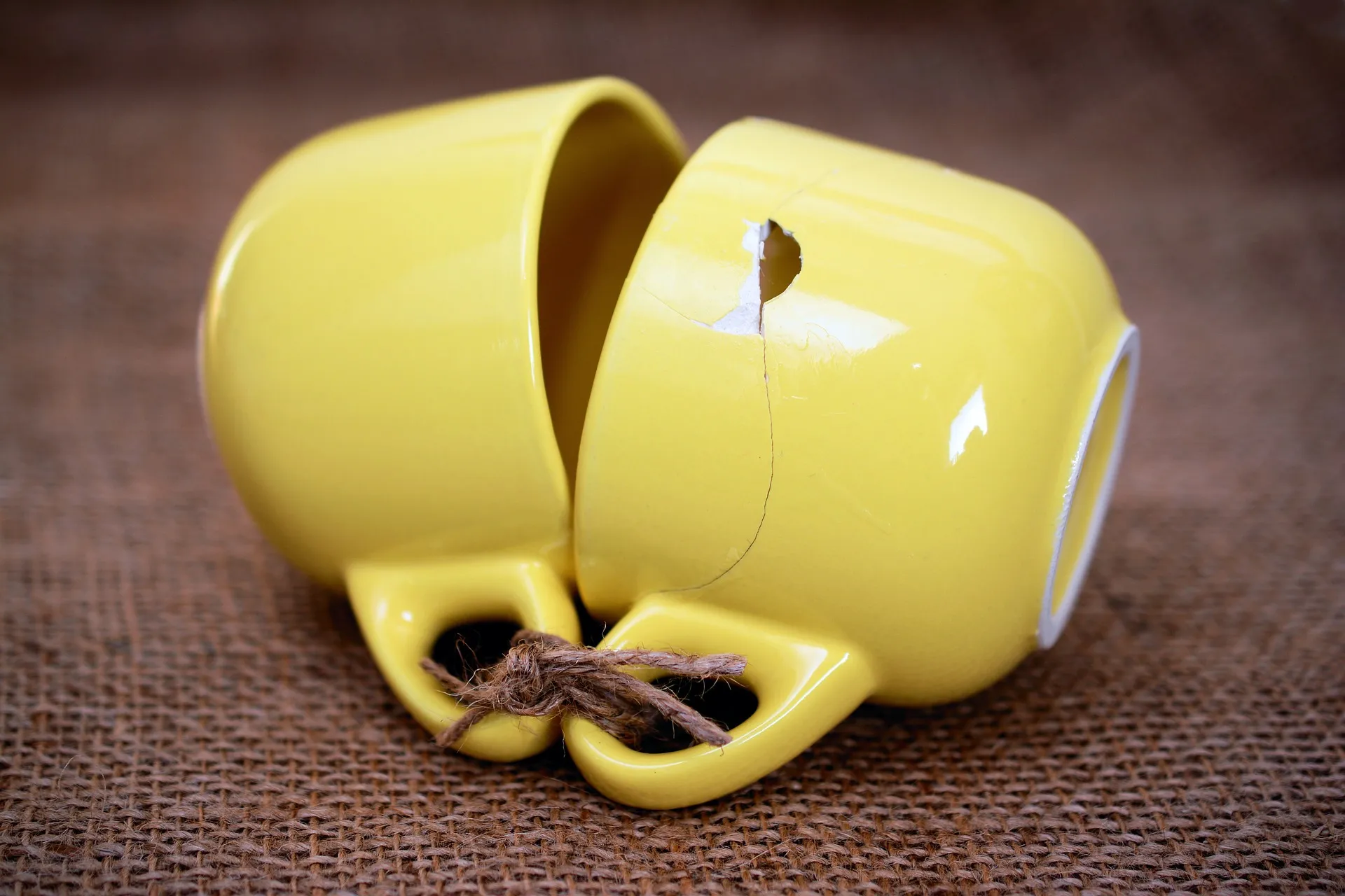 gelbe Tassen mit Schnur verbunden