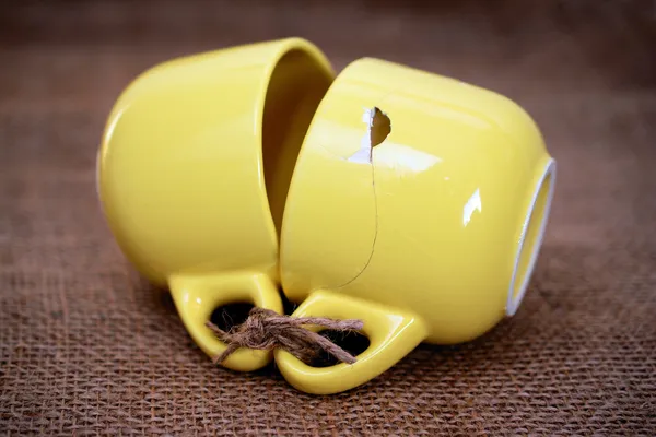 gelbe Tassen mit Schnur verbunden