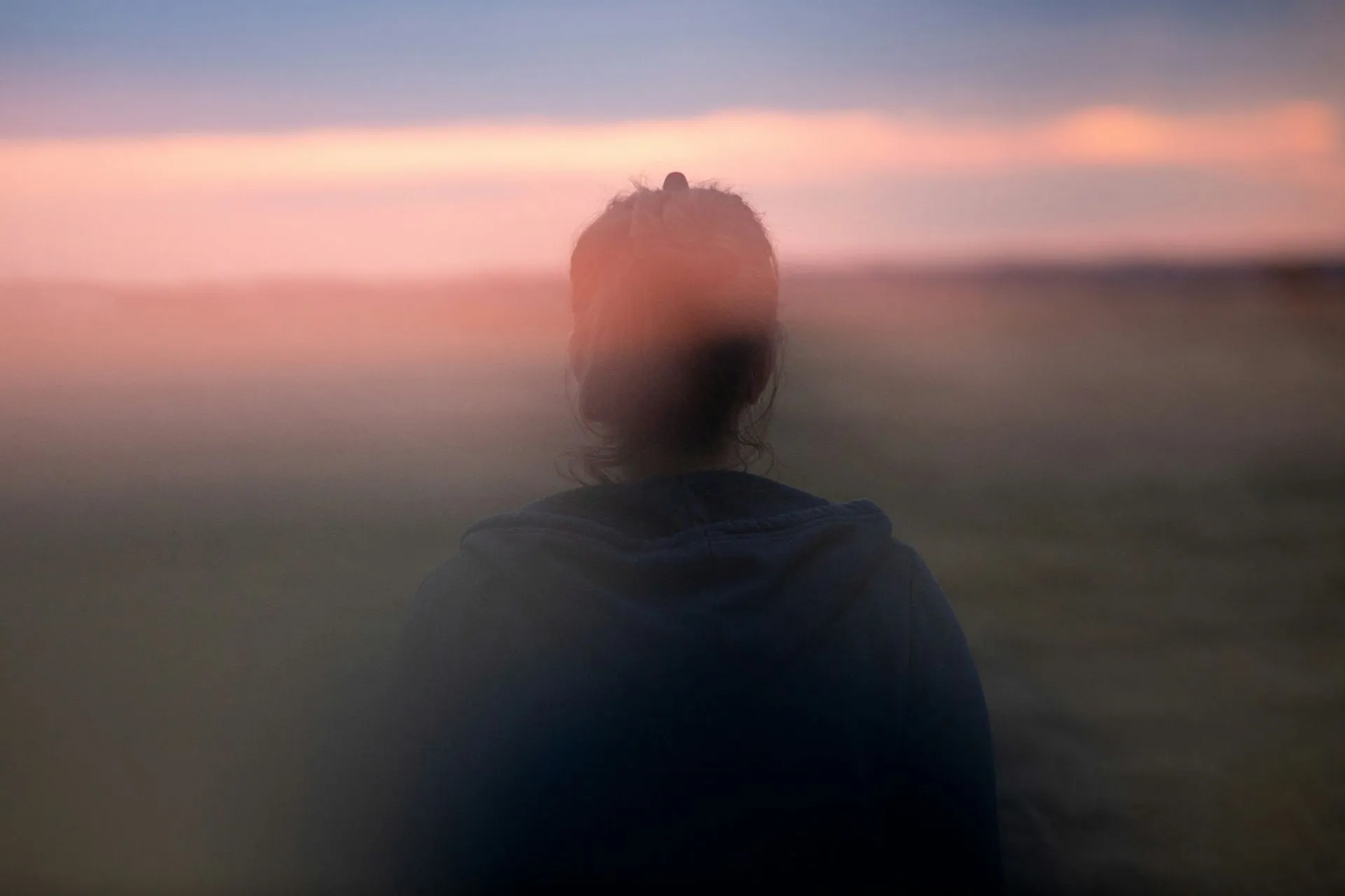 Person im Nebel blickt in die Weite