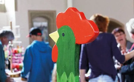 Grüner Holzgockel und Menschen im Hintergrund