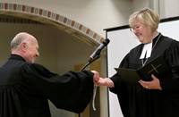 Urs Keller übergibt Landesbischöfin Springhart seine Kette mit Kreuz