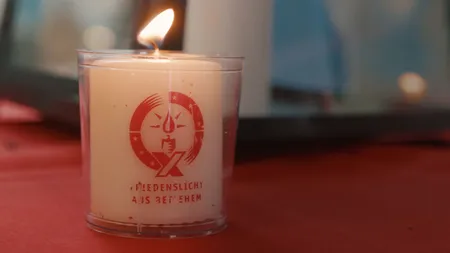 Brennende Kerze mit dem Friedenslicht aus Bethlehem