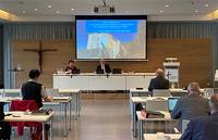 Präsidium der Landessynode vor großer Leinwand im Haus der Kirche