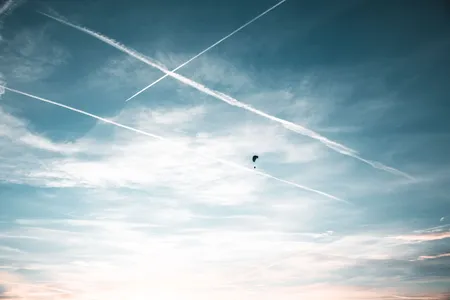 Quelle: Ryan Klaus I pexels.com Himmel mit Kondesstreifen und Gleitschirmflieger