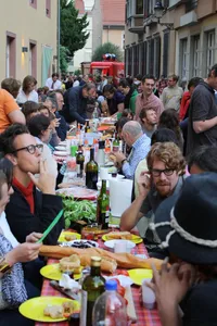 Gedeckter Tisch mit Menschen beim Straßenfest