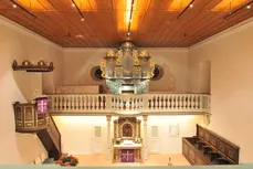 Blick durch den Innenraum der Kirche Hirschlanden auf Altar und Orgel
