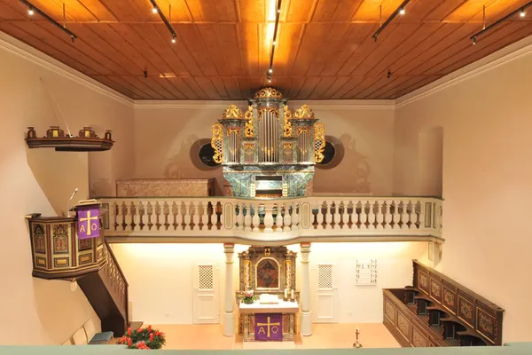 Blick durch den Innenraum der Kirche Hirschlanden auf Altar und Orgel