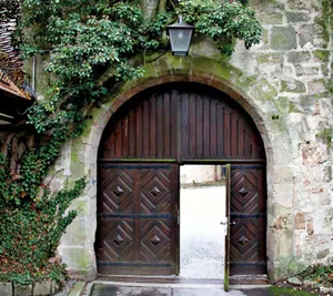 Offne Tür in ene Bogenhoftor eine alten Gebäudes