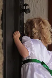 Kind lugt durch angelehnte Türe