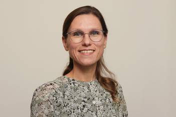 Portraitfoto der Theologin Dr. Antonia Lüdtke, eine junge Frau mit langen dunkelblonden Haaren und einer großen Brille
