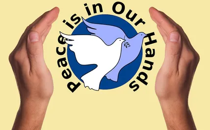 Blauer kreis mit zwei Friedenstauben um den Kreis der Text: Peace is in ouer hands , gehalten von 2 Händen rechts und links