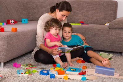 Mutter mit zwei Kindern und Bilderbuch