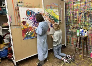 malende Frauen an einer großen Leinwand