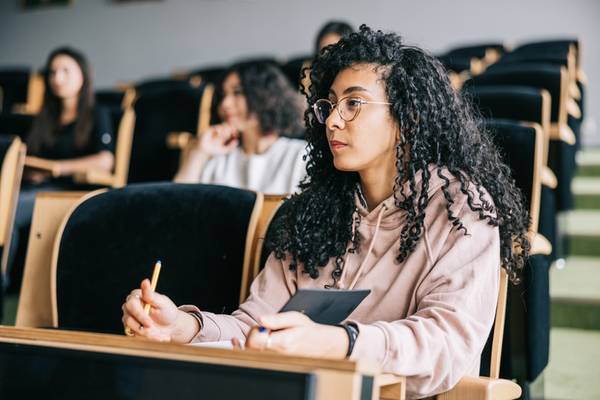 Schülerinnen und Schüler, die in einem Hörsaal einer Universität sitzen.