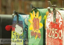 Ein Bild mit aneinader gereihten buten amerikanischen Breifkästen. Darunter die Worte: Kummerkasten sein"