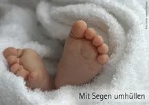 Eine kuschelige warme wieße Decke, aus der unten ein paar Säuglingsfüße heraus schauen