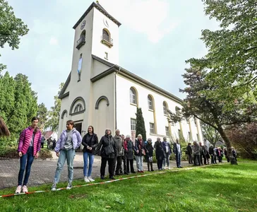 Kirche in Friedrichstal mit Menschenkette davor