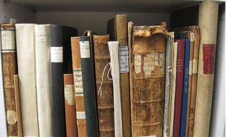 Rücken von alten Kirchenbüchern und Rechnungsbänden mit Signaturschildern