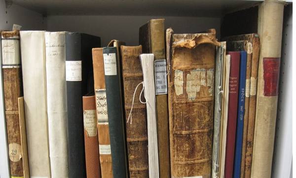 Rücken von alten Kirchenbüchern und Rechnungsbänden mit Signaturschildern