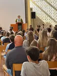 Gottesdienstbesucherinnen und -besucher hören der Predigt zu