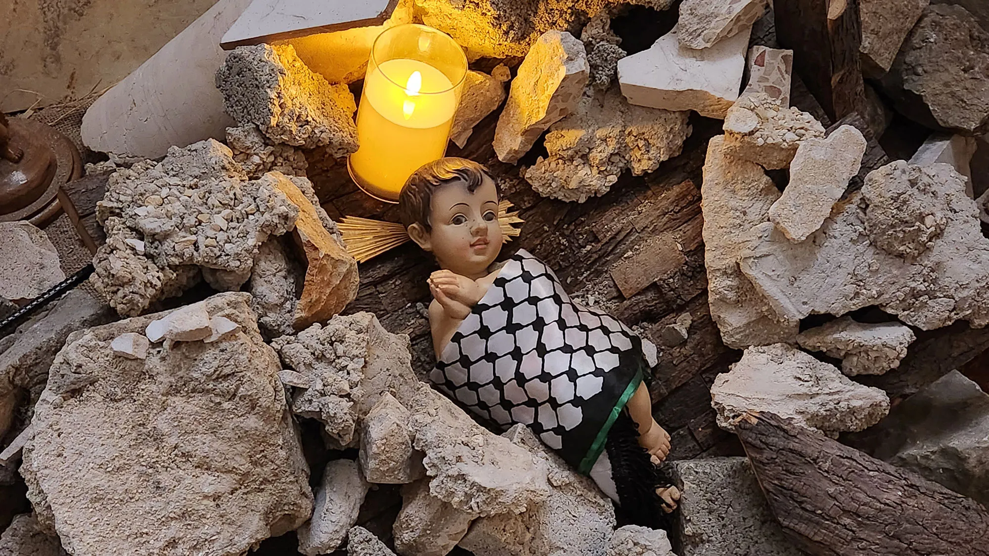 Jesusfigur liegt in einer Krippe aus Trümmerteilen