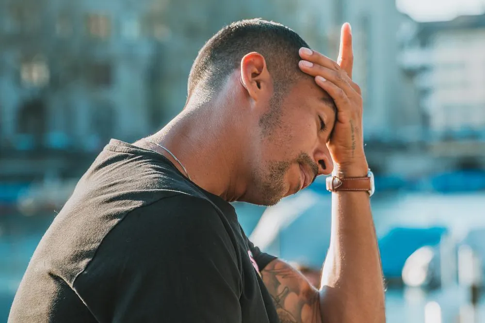 Mann stützt Kopf auf Hand