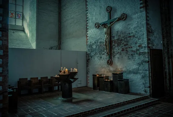 Innenraum einer Kirche mit Kerzen und Kreuz